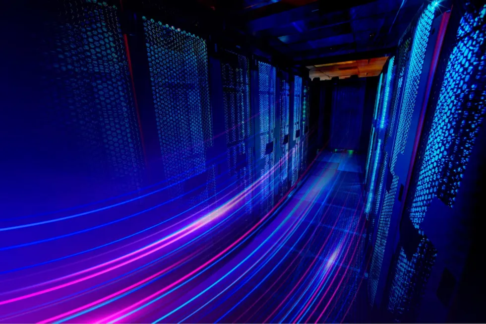 A data centre server corridor lit with blue and pink light trails